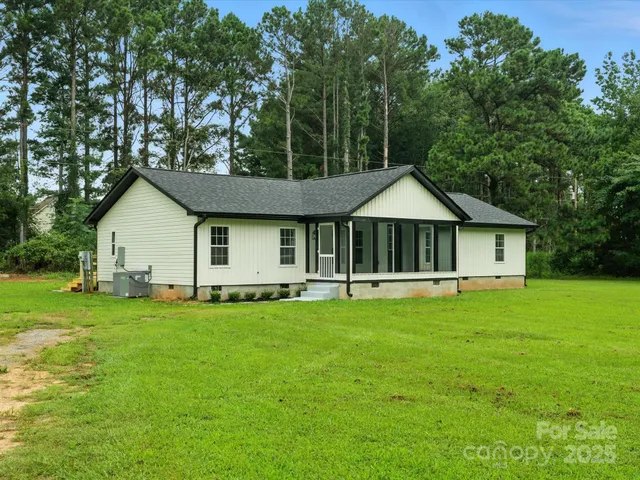 a front view of a house with a garden and trees