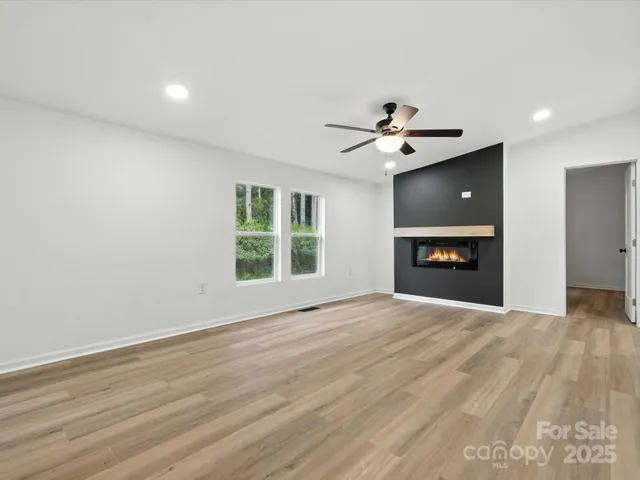 a view of an empty room with a fireplace and a window