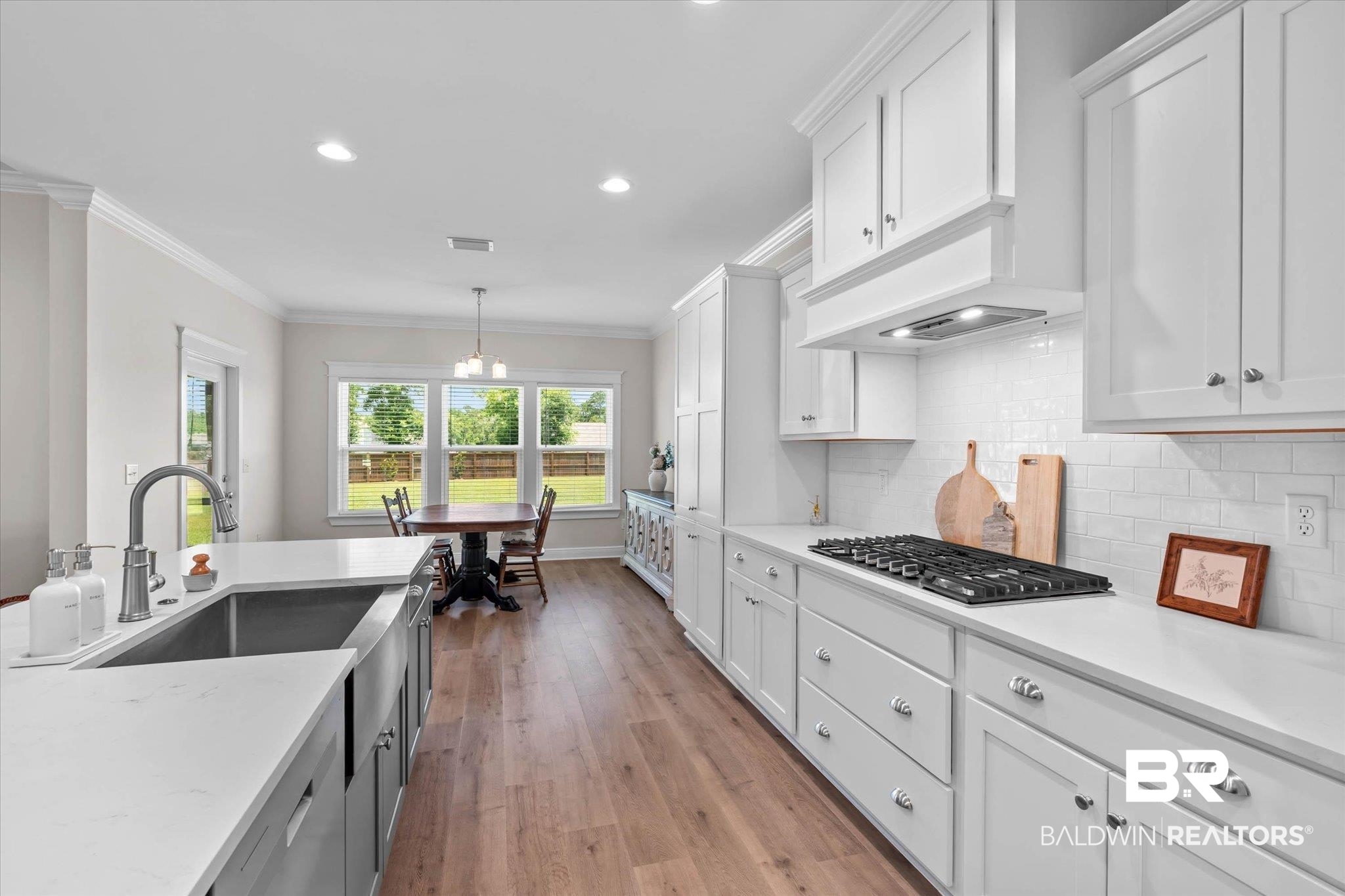23523 Travis Stock Street Foley, AL 36535 - Photo 11 of 45 Kitchen featuring white cabinetry, wood-finish flooring, and white countertops