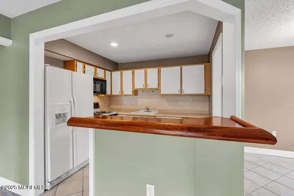 a kitchen with stainless steel appliances granite countertop a sink and a refrigerator