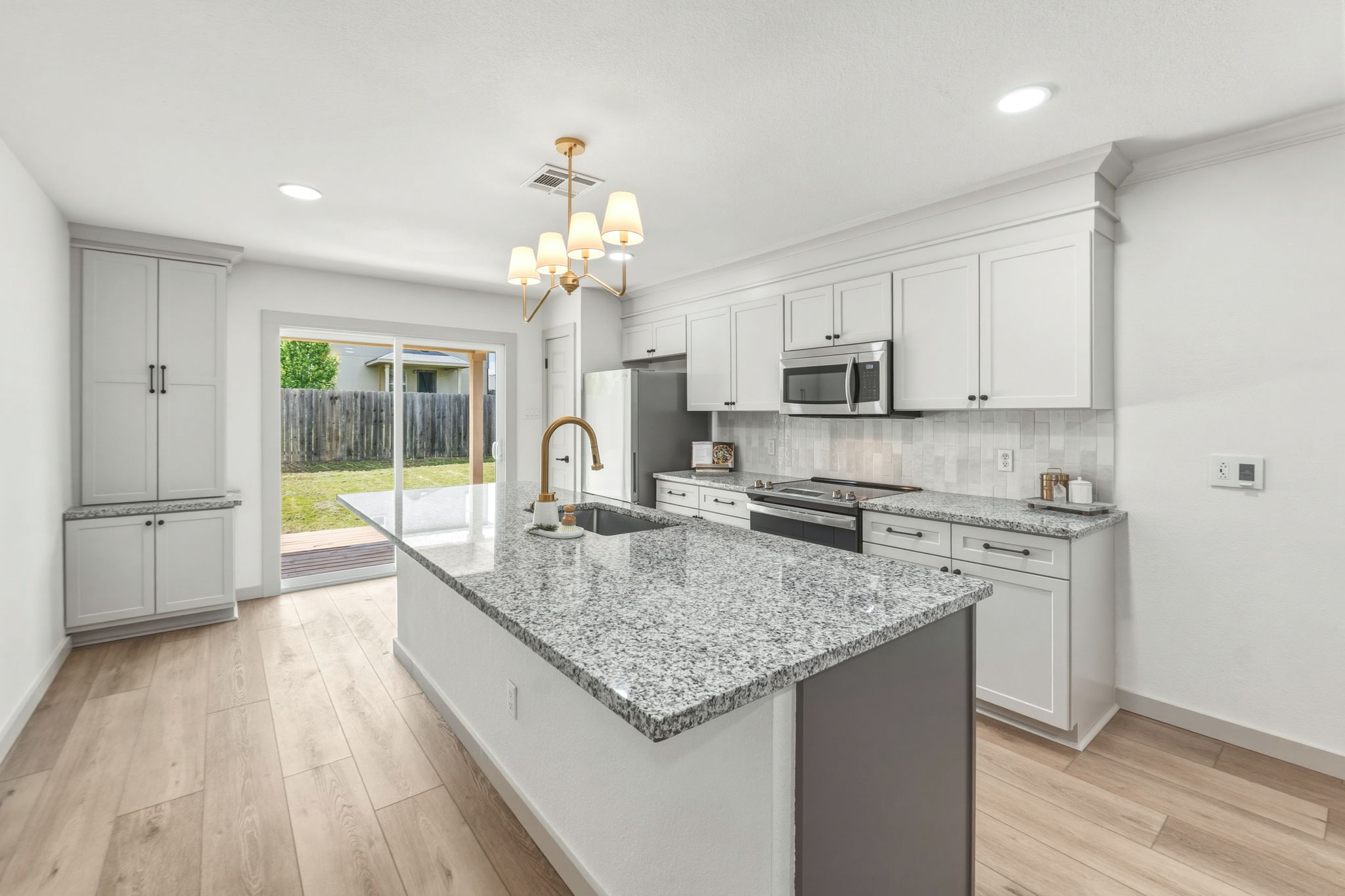 211 Banner Avenue Leander, TX 78641 - Photo 6 of 27 a kitchen with stainless steel appliances granite countertop a sink a stove and a wooden floors