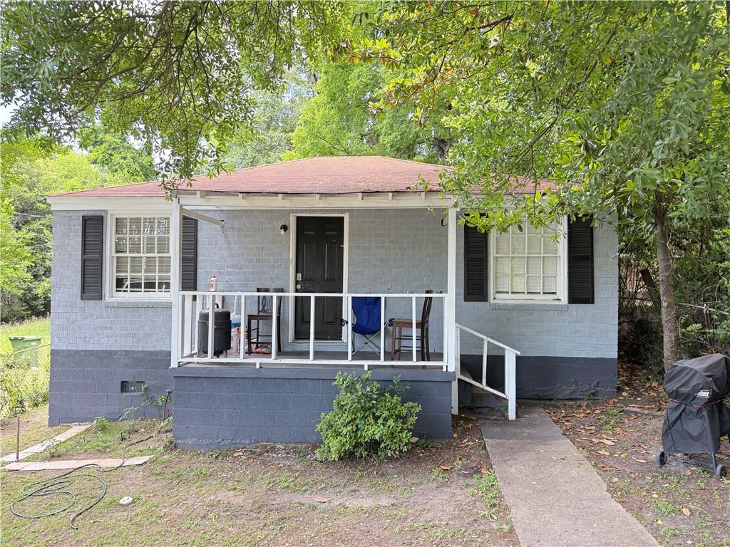 a view of a house with a yard and potted plants
