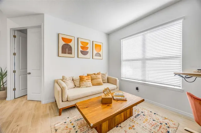 a kitchen with stainless steel appliances a dining table chairs and refrigerator