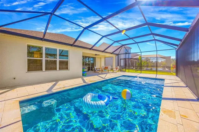 an aerial view of a swimming pool with outdoor seating