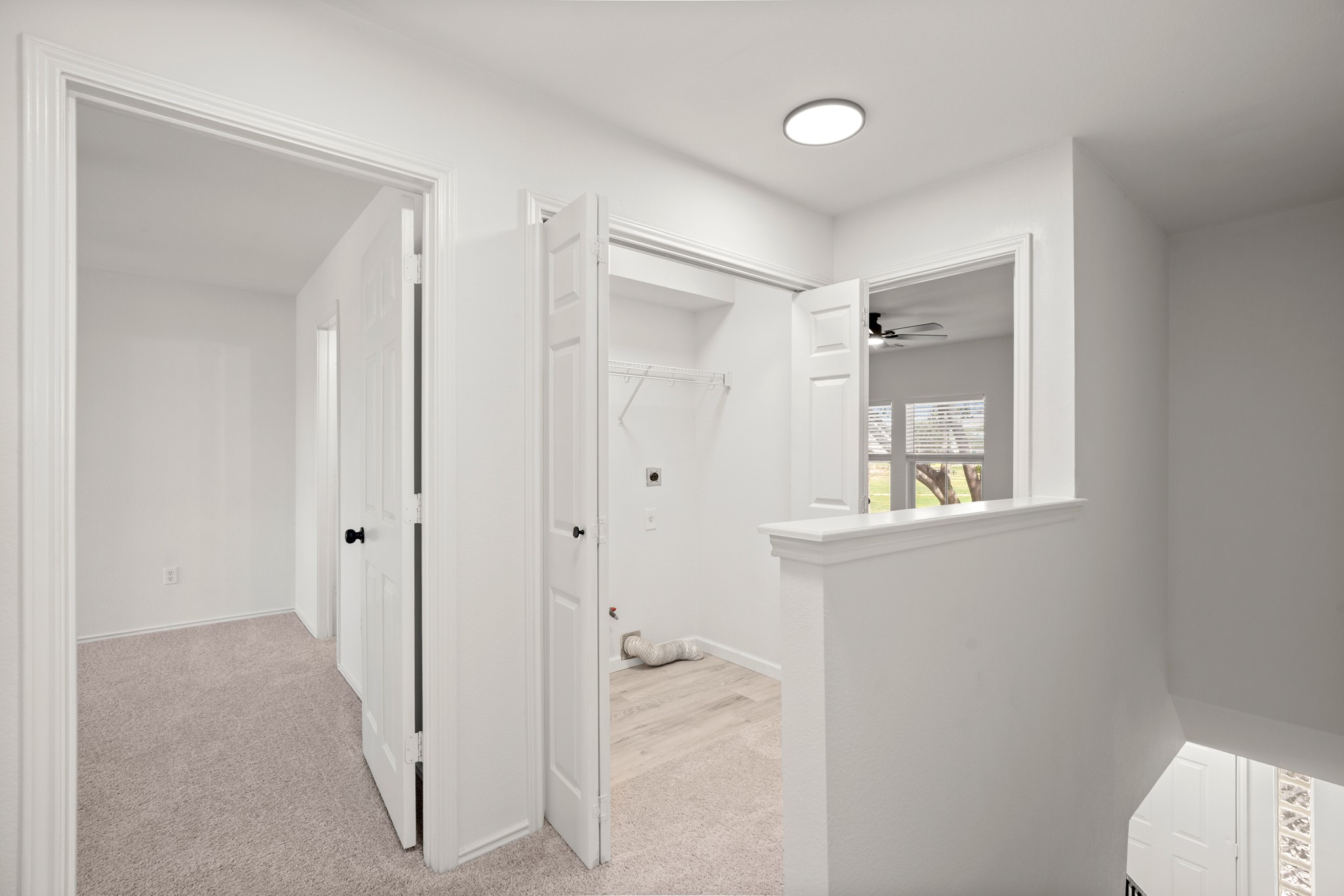 360 Sampson Kyle, TX 78640 - Photo 10 of 36 Upper-level hallway laundry room featuring light-toned carpeting and white walls