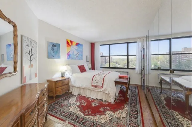 a bedroom with a bed and a large window with outer view