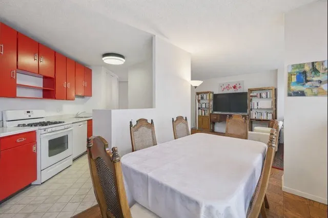 a kitchen with stainless steel appliances a stove a refrigerator a sink dishwasher with a dining table and chairs