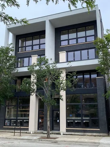 a front view of a building with a garden