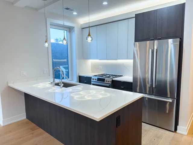 a kitchen with kitchen island a counter top space cabinets and stainless steel appliances