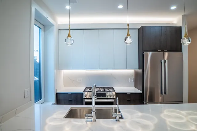 a view of a kitchen with stainless steel appliances granite countertop a refrigerator and a sink