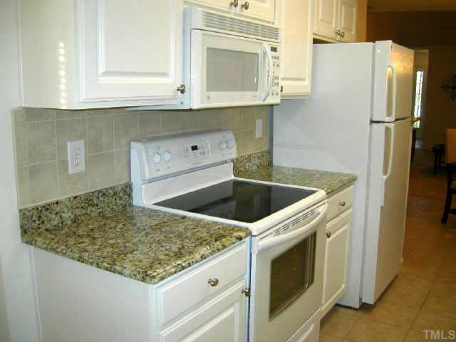 11321 Clubhaven Place Raleigh, NC 27617 - Photo 3 of 10 a kitchen with granite countertop a sink and a refrigerator