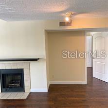 365 Forestway Circle, Unit 306 Altamonte Springs, FL 32701 - Photo 3 of 17 a view of an empty room with wooden floor and a fireplace