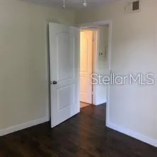 an empty room with wooden floor and window