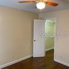 an empty room with wooden floor and mirror