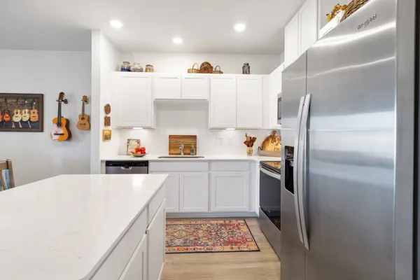 a kitchen with a refrigerator and white cabinets