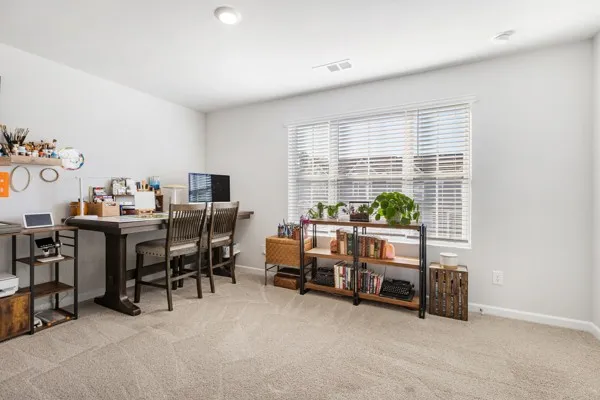 a view of a workspace with furniture and a window