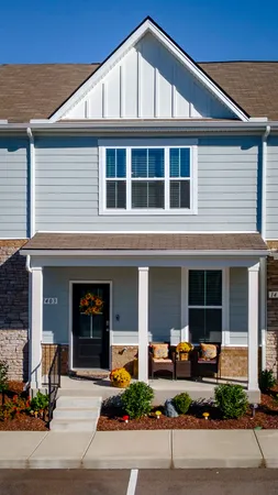 a front view of a house with lots of windows and plants