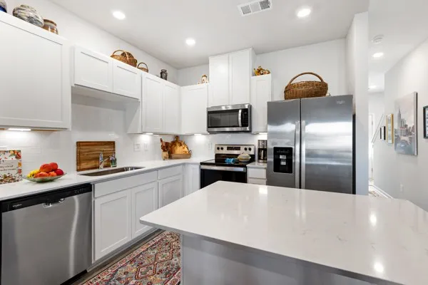a kitchen with stainless steel appliances a refrigerator sink and microwave