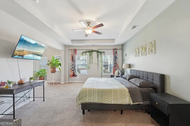 a bedroom with a bed couch and a large window