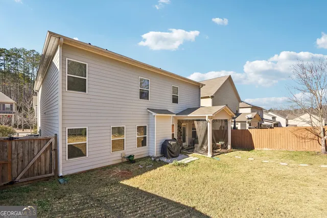 a backyard of a house with yard and outdoor seating