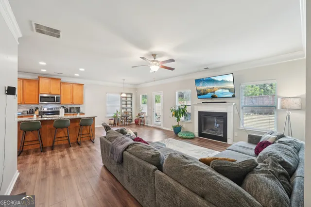 a living room with furniture a fireplace and a large window