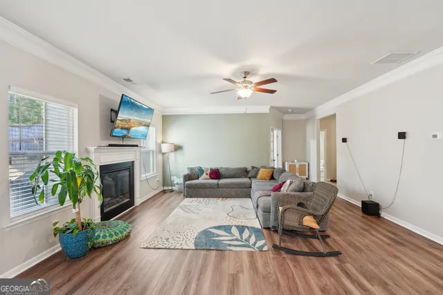 a dining room with furniture potted plants and wooden floor