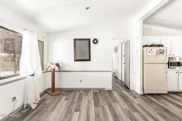 a kitchen with sink a refrigerator and white cabinets