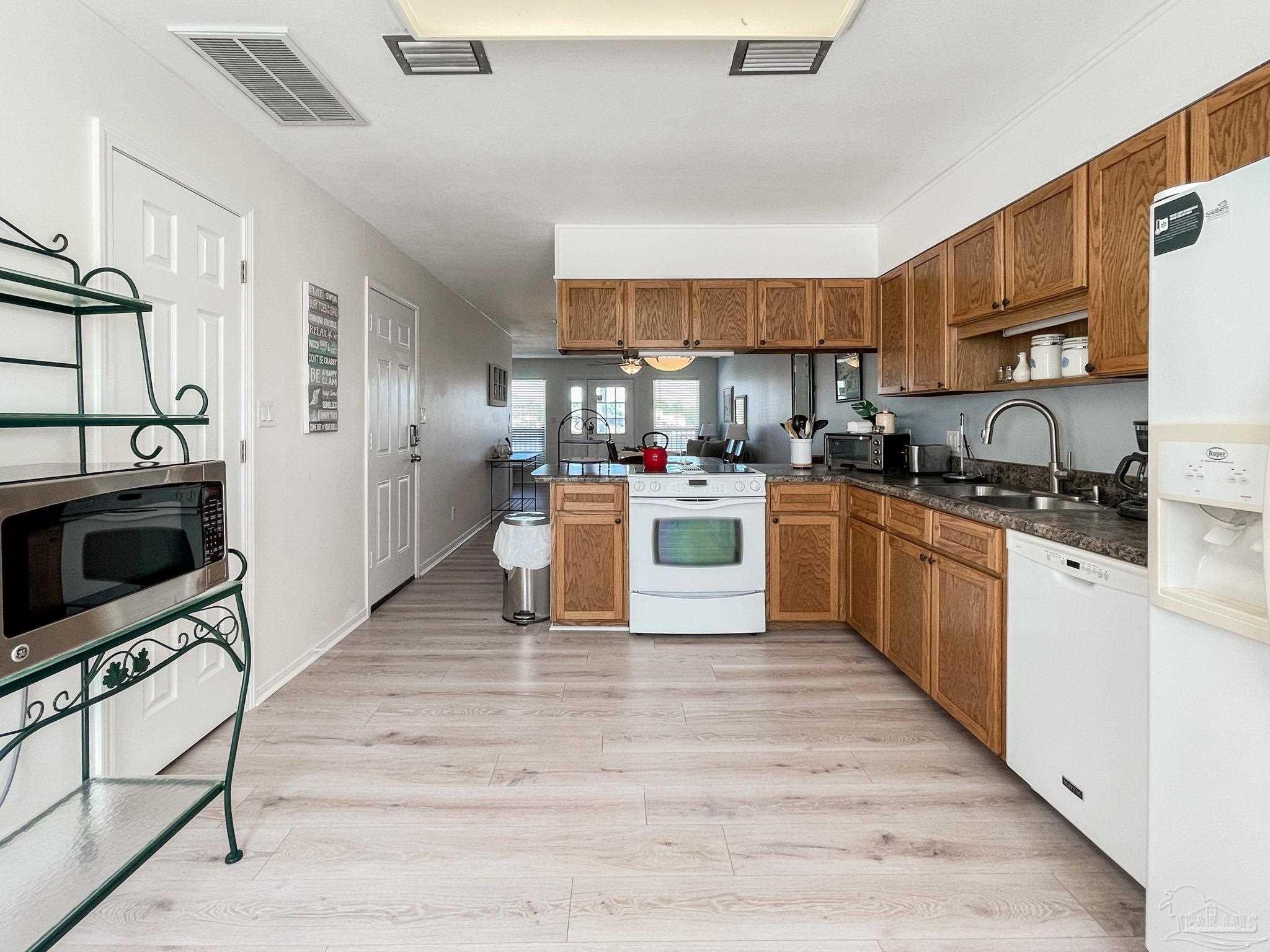 13948 River Road, Unit 3A Pensacola, FL 32507 - Photo 21 of 47 a kitchen with stainless steel appliances granite countertop a stove top oven a sink dishwasher and a refrigerator