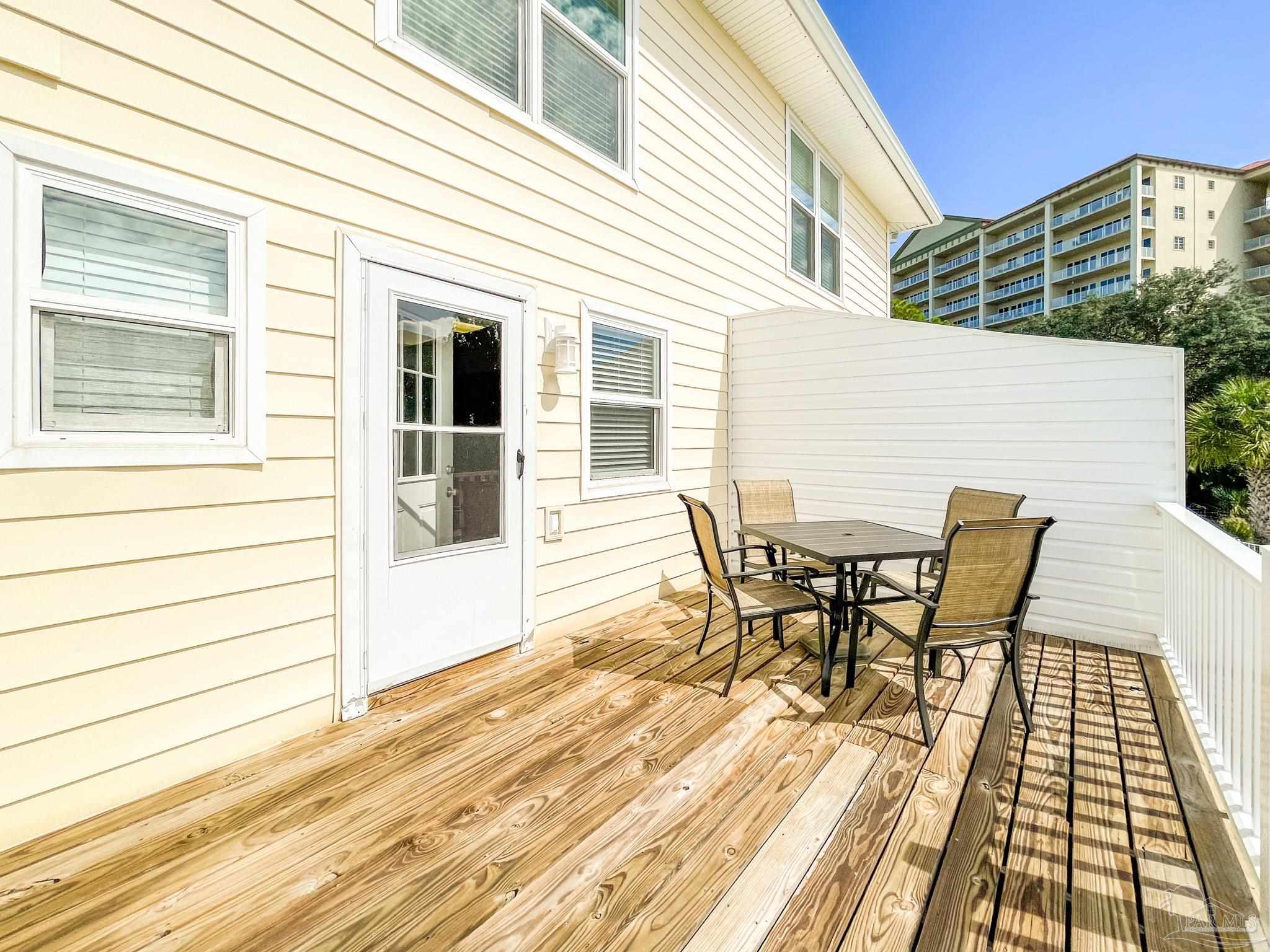 13948 River Road, Unit 3A Pensacola, FL 32507 - Photo 26 of 47 a view of a roof deck with table and chairs and wooden floor