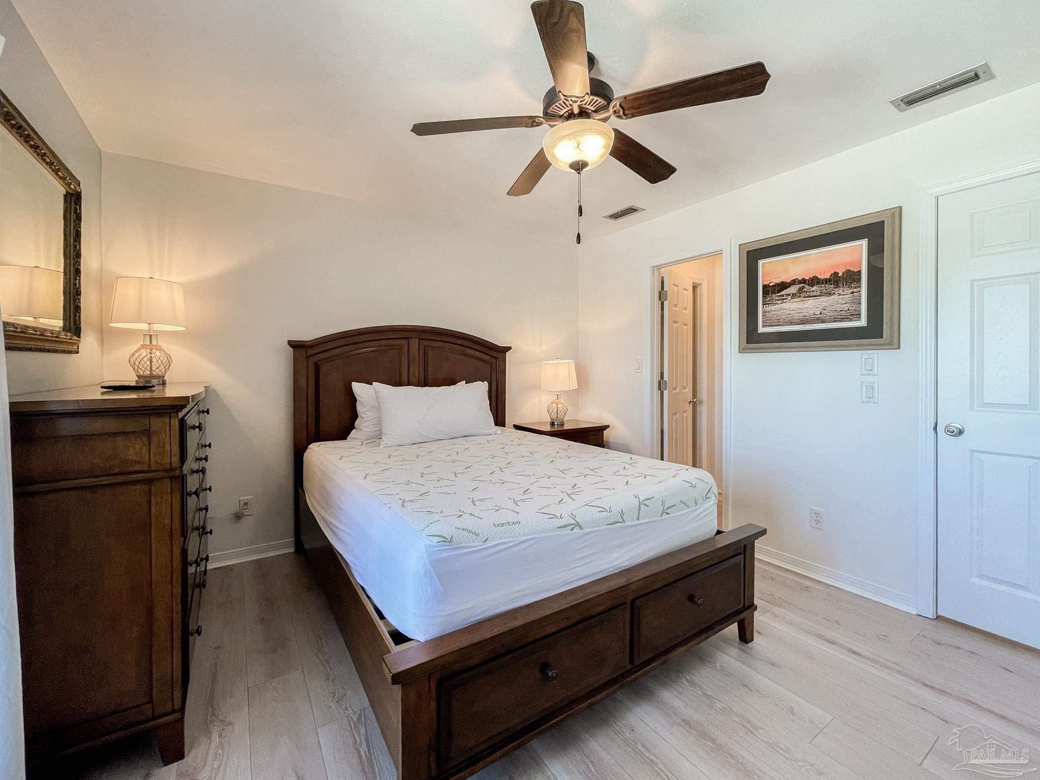 13948 River Road, Unit 3A Pensacola, FL 32507 - Photo 29 of 47 a bedroom with a bed and a chandelier