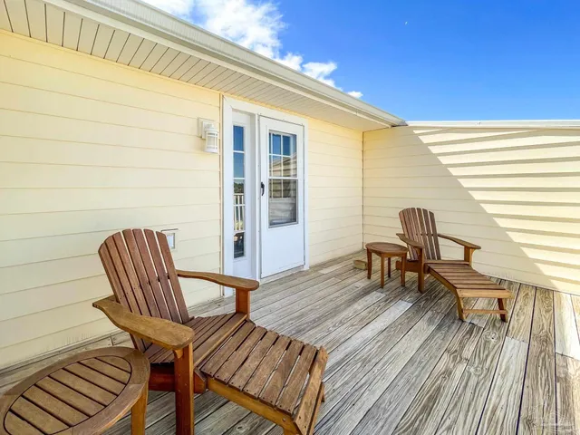 a balcony with chairs and wooden floor