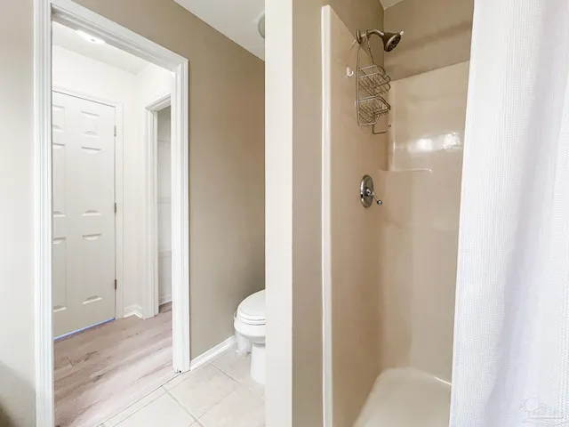 a bathroom with a granite countertop shower and a toilet