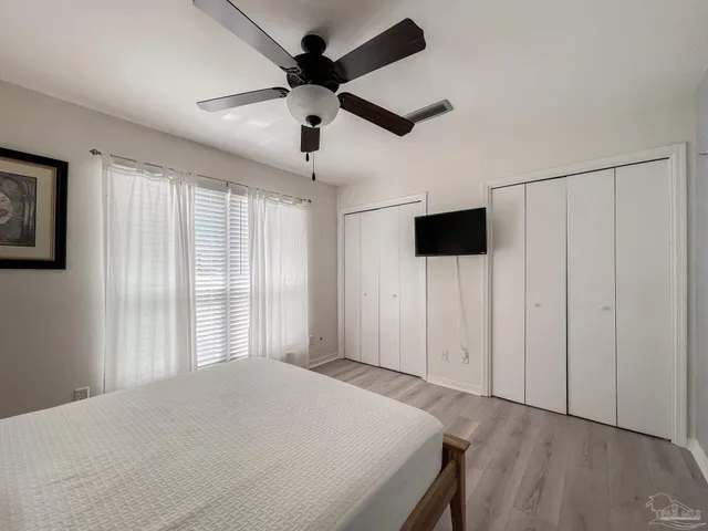 a bedroom with a large bed a flat tv screen and a window