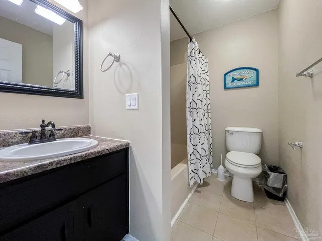a bathroom with a granite countertop sink a toilet and a mirror