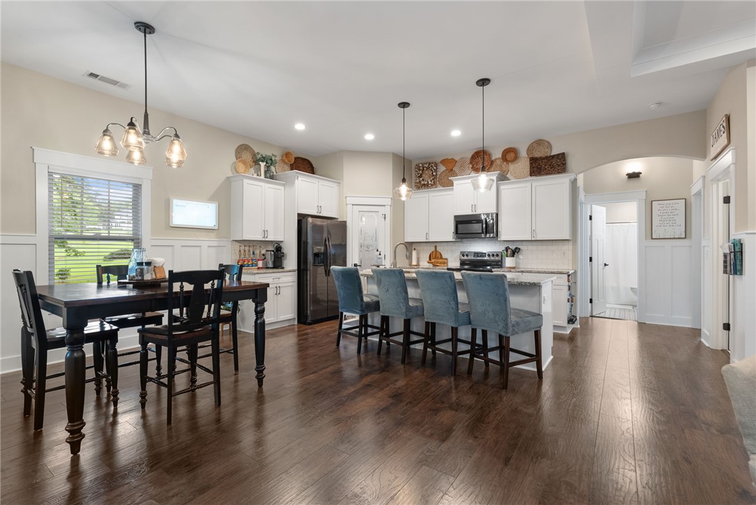 201 Hearthstone Drive Anderson, SC 29621 - Photo 16 of 49 An open-concept kitchen and dining area features rich hardwood flooring and a functional island with seating.