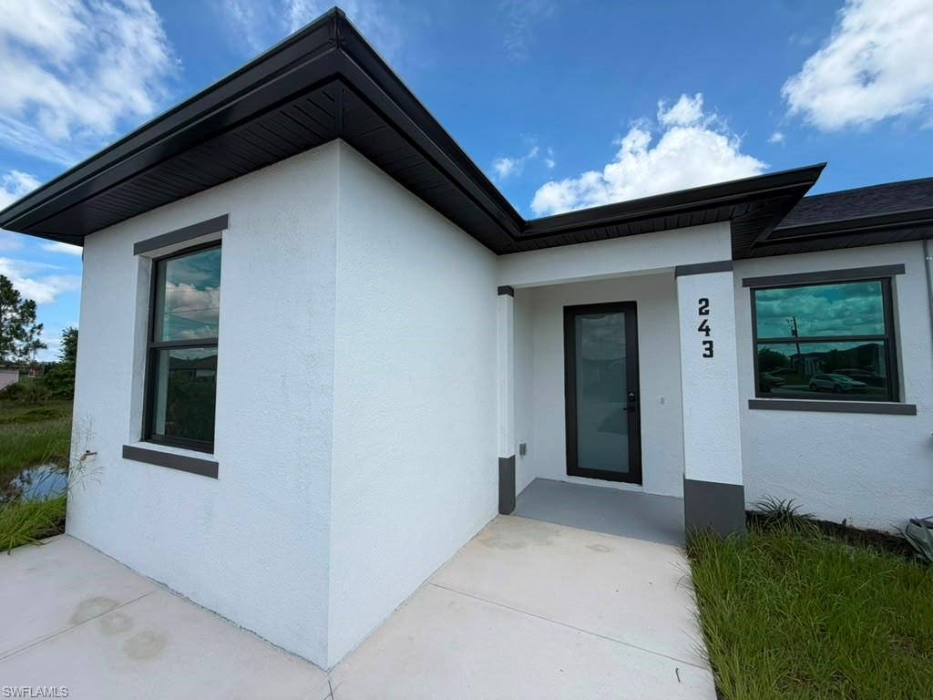 907 Homestead Road South Lehigh Acres, FL 33974 - Photo 6 of 43 Contemporary exterior featuring white stucco and dark trim