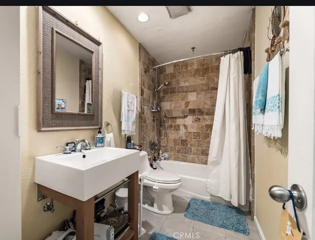 a bathroom with a sink toilet a mirror and shower