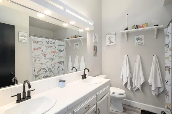 a bathroom with a sink vanity mirror and toilet