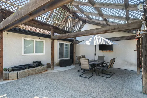 a view of a patio with a table and chairs under an umbrella