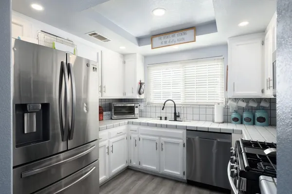a kitchen with a sink stainless steel appliances and cabinets