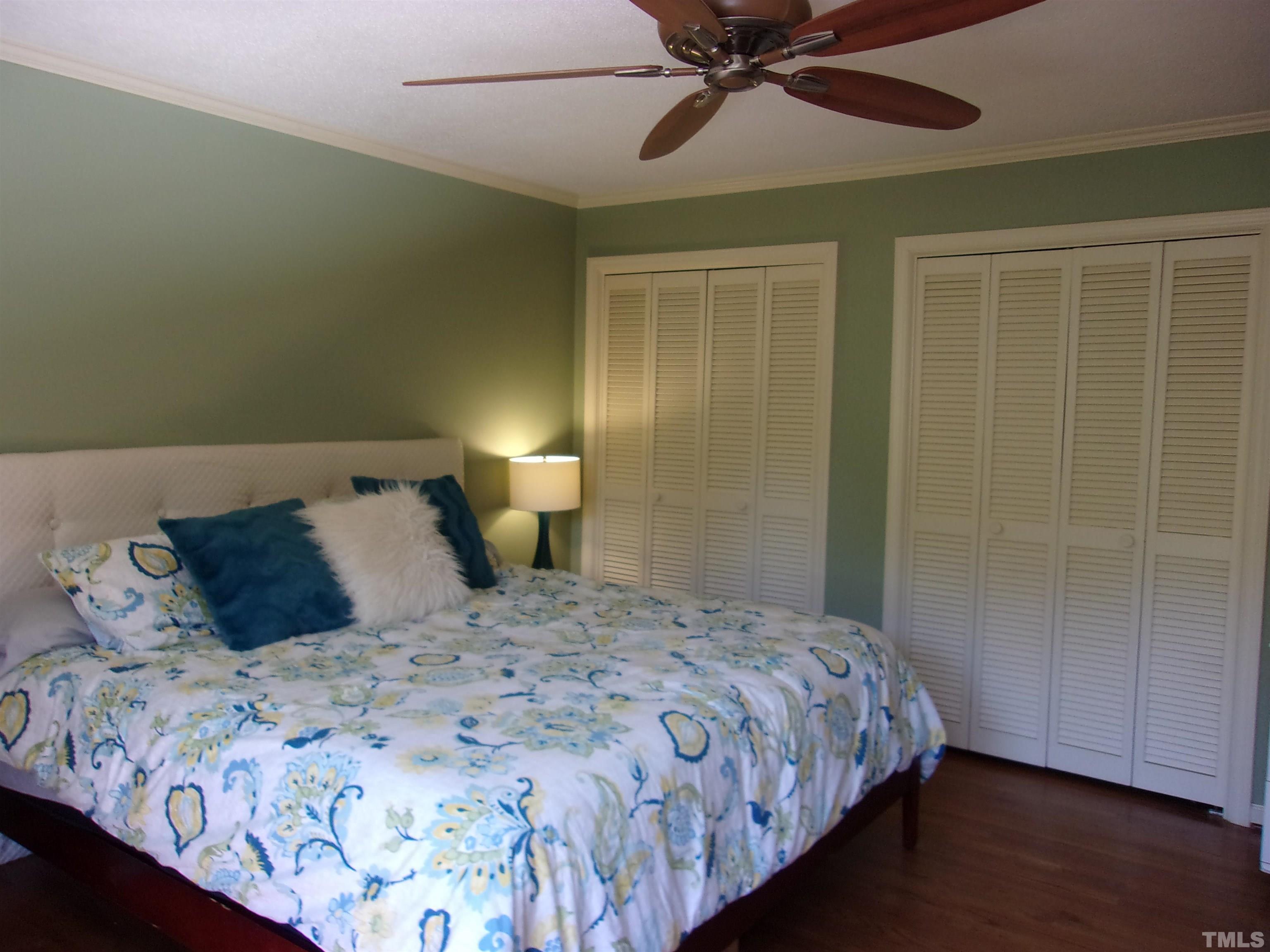 8709 Oneal Road Raleigh, NC 27613 - Photo 11 of 20 a bedroom with a large bed and a chandelier