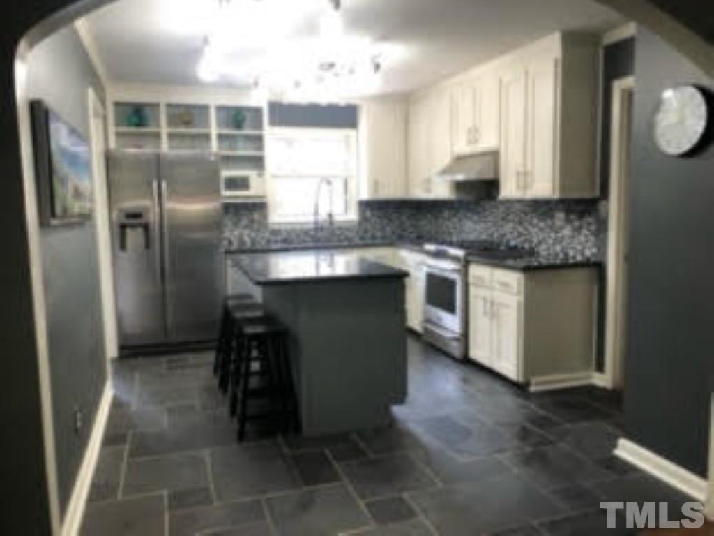 8709 Oneal Road Raleigh, NC 27613 - Photo 7 of 20 a kitchen with stainless steel appliances granite countertop a sink stove and refrigerator