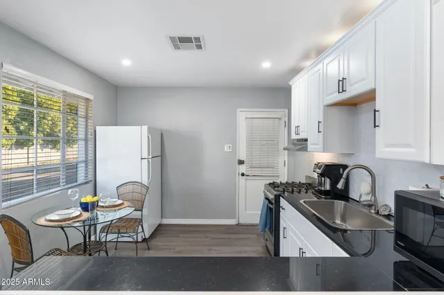 a kitchen with a refrigerator a sink a stove and a cabinets