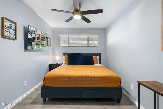 a bedroom with a bed and painting on the wall