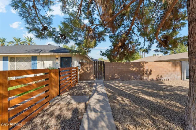 a view of a chairs and table in the patio next to a yard