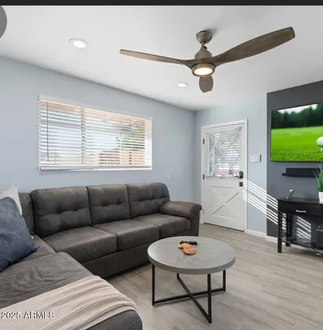 a living room with furniture kitchen view and a window
