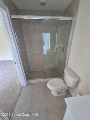 a bathroom with a toilet and a shower