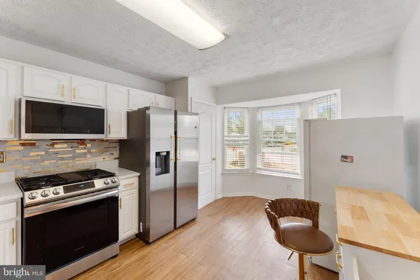 a kitchen with stainless steel appliances a stove a microwave and a refrigerator