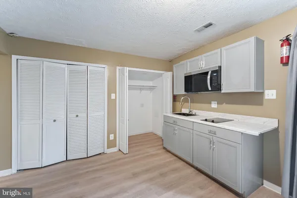 a kitchen with a sink cabinets and wooden floor