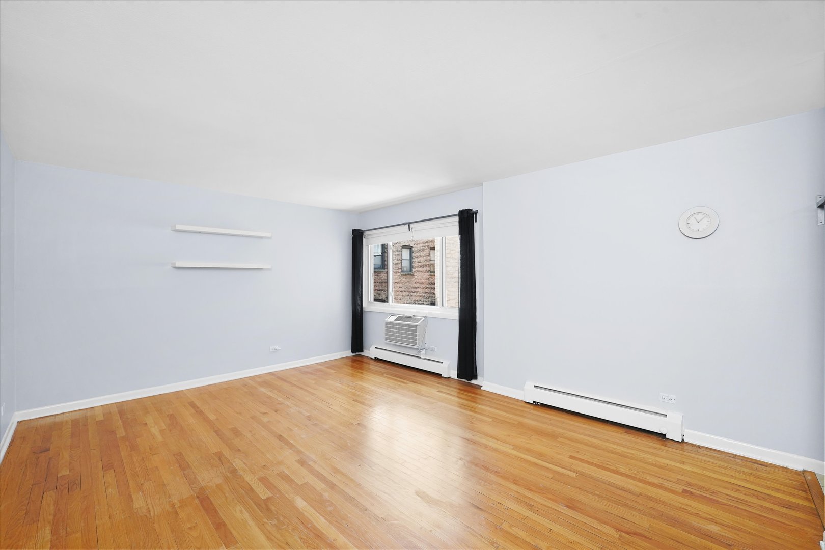 7120 North Sheridan Road, Unit 404 Chicago, IL 60626 - Photo 3 of 21 an empty room with wooden floor and windows